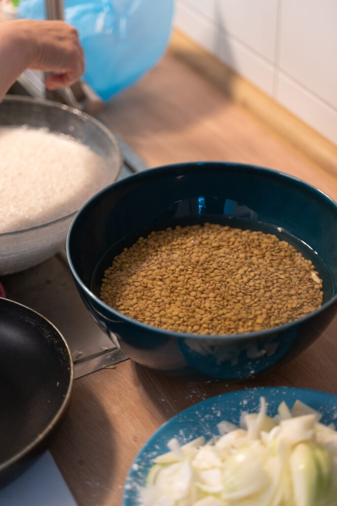 In einer großen Schüssel werden Linsen in Wasser eingeweicht.