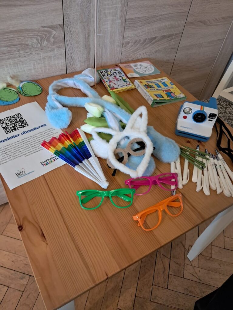 Auf einem Tisch liegen Hasenohren, Flyer und Blumen.