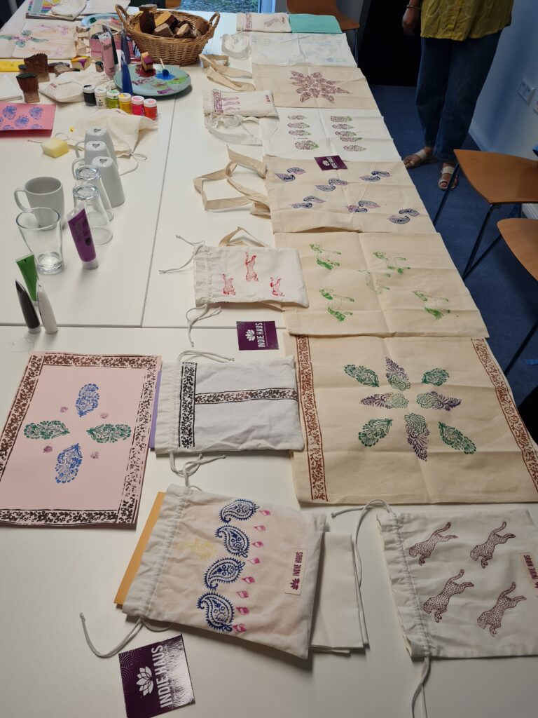 Auf einem Tisch liegen viele bedruckte Stofftaschen