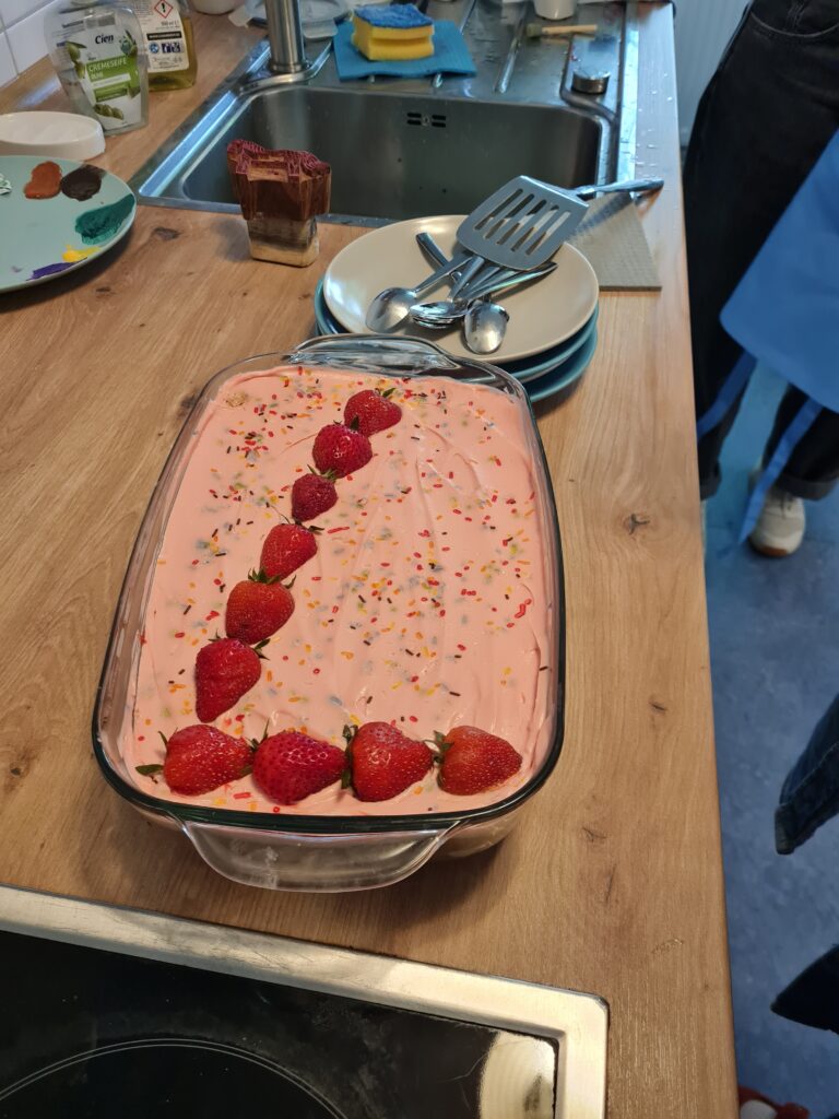 Ein Kuchen ist mit Erdbeeren und Streuseln dekoriert.