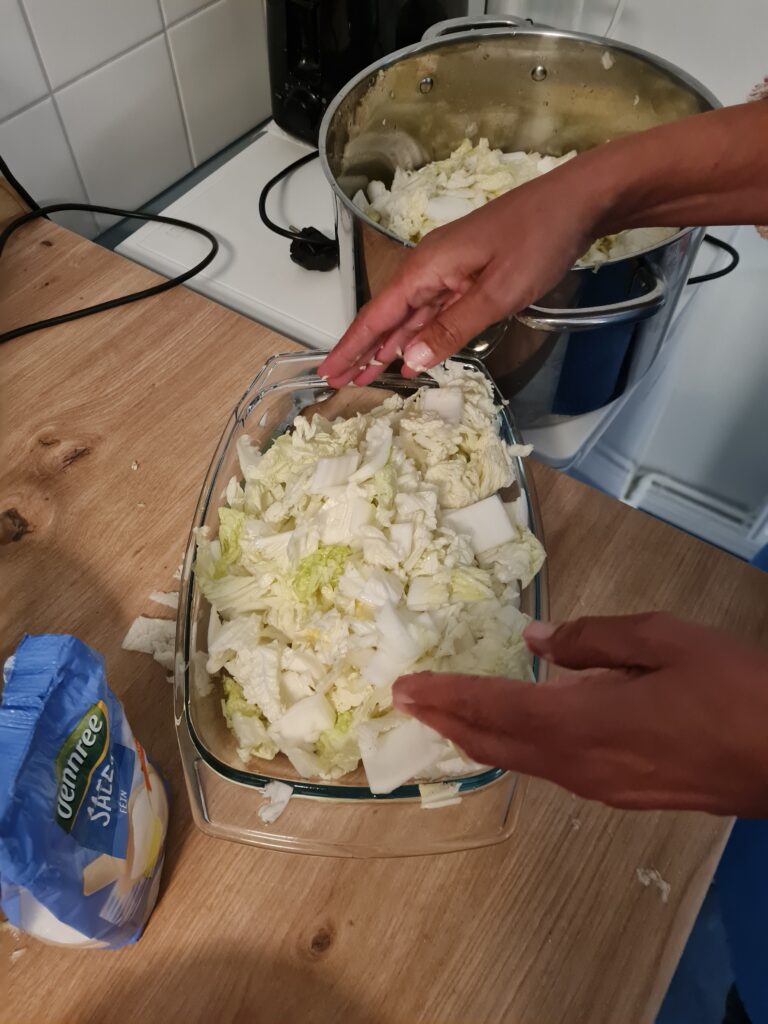 Eine Schüssel mit geschnittenem Kohl und Händen.